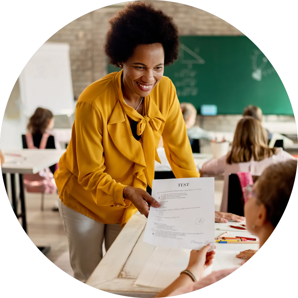 Smiling teacher handing a graded test back to a student in class